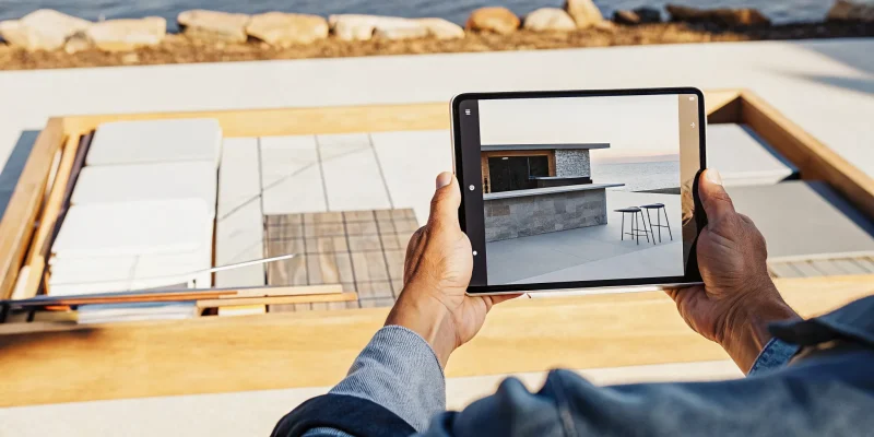 Outdoor kitchen contractor plans a design on a tablet at a waterfront Long Island, NY home.