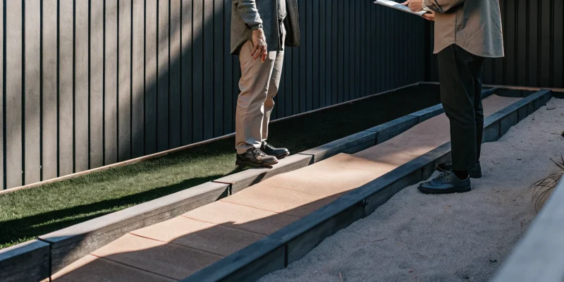 Getting a quote for turf installation from a professional in a backyard.