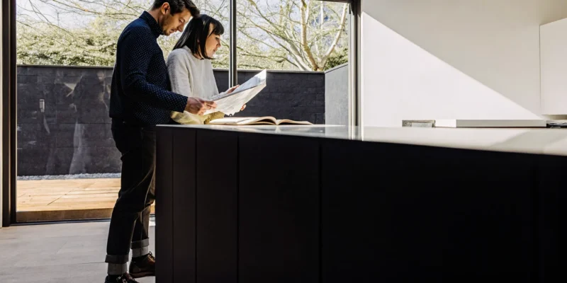 Couple reviewing plans to find the best builders for their kitchen extension.