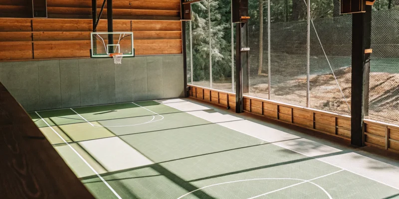 Custom indoor sports court with a basketball hoop, professionally installed by court builders.