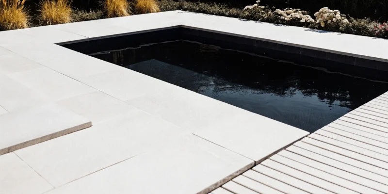 Custom gunite swimming pool with natural stone coping and blue water in a Long Island backyard
