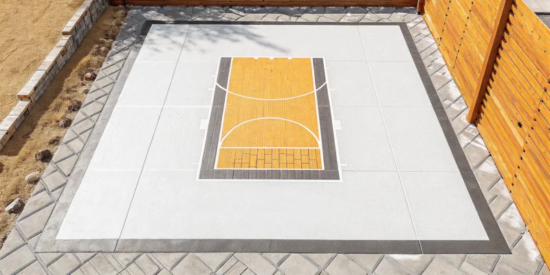 A professional backyard basketball court installation with a custom modular tile surface.