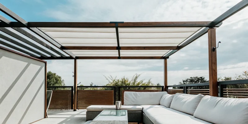Custom wood pergola with a modern design, white canopy, and outdoor seating area.