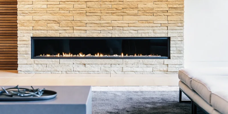 Modern natural stone fireplace wall with a sleek linear gas fire.