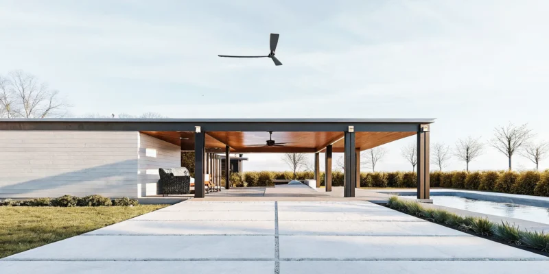 Modern outdoor living pavilion in Nassau County providing shade for a poolside seating area.