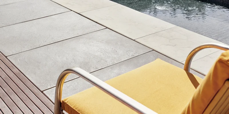 A luxury porcelain paver pool deck surrounding a swimming pool in Long Island.