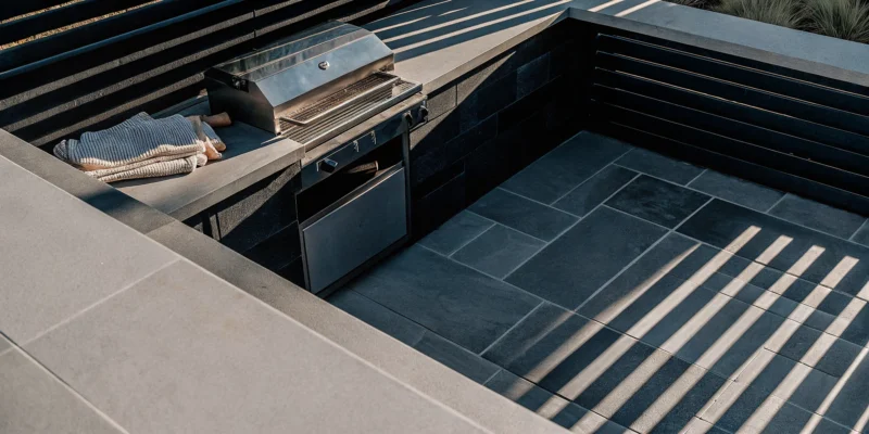 The cost of an outdoor kitchen in Long Island with a stainless steel grill and stone countertops.