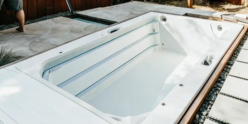 An in-ground swim spa sits in a concrete vault during installation.