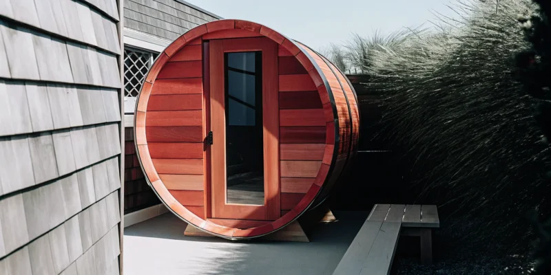 A wooden barrel sauna with a glass door from a top barrel saunas company in Long Island.